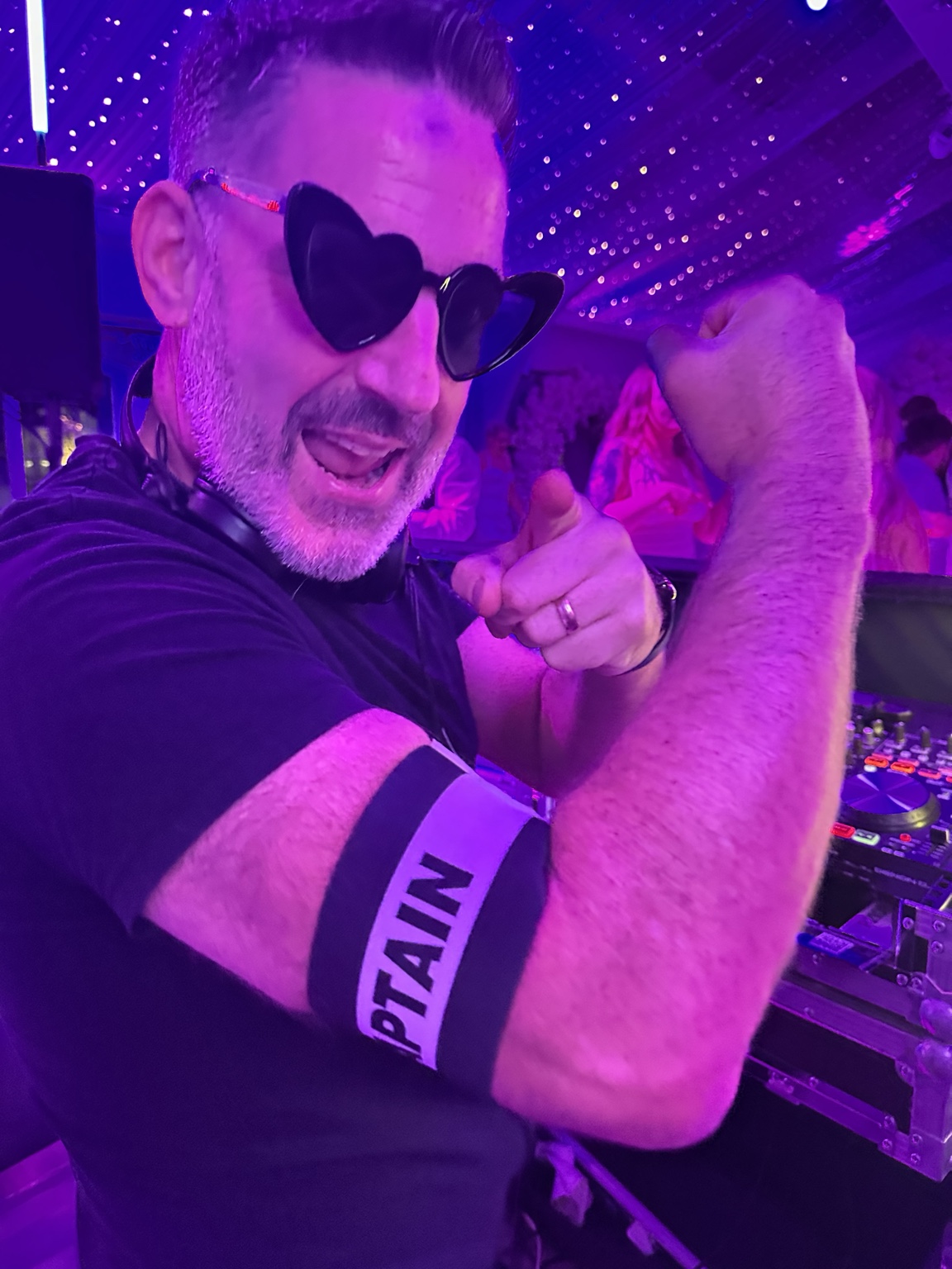 DJ Andy Murphy wearing heart-shaped sunglasses beside his decks at the evening reception