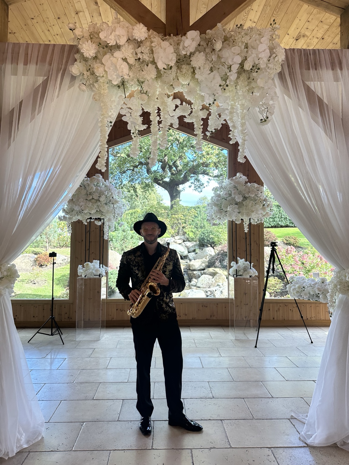 Spencer beneath the white floral arch in Colshaw Hall’s ceremony room