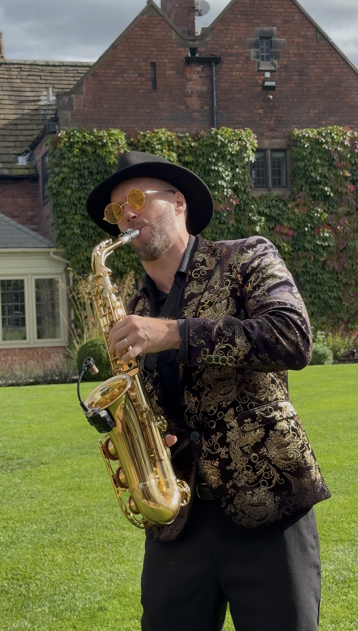Spencer playing sax on the lawn outside Colshaw Hall