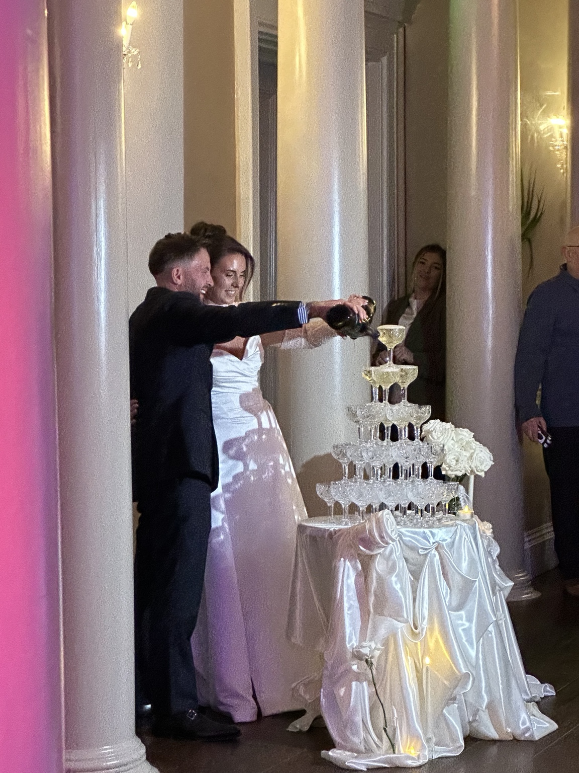 Joanna and Josh pouring drinks into a champagne tower