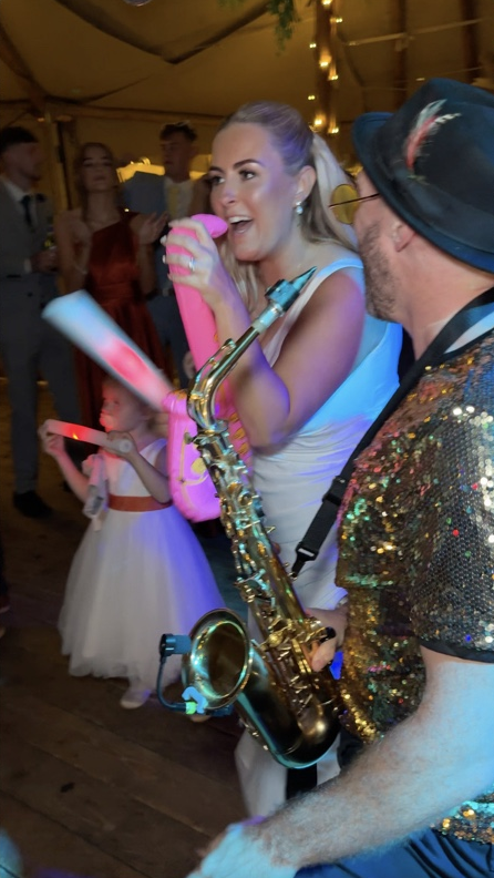 Claire enjoying her inflatable sax alongside Spencer on the dance floor