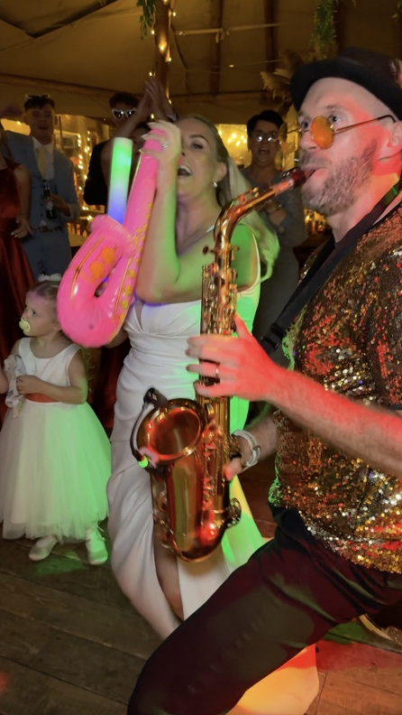 Claire with her pink inflatable sax alongside Spencer playing live sax